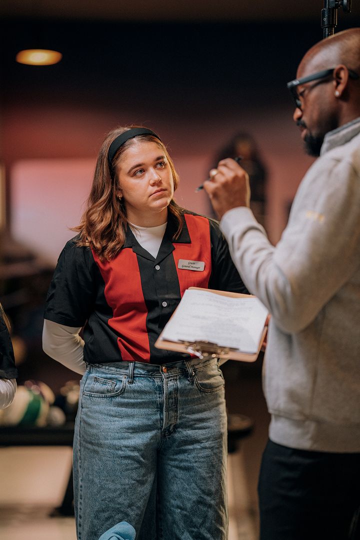 Director giving script notes to an actor on the bowling alley set of The Long Game