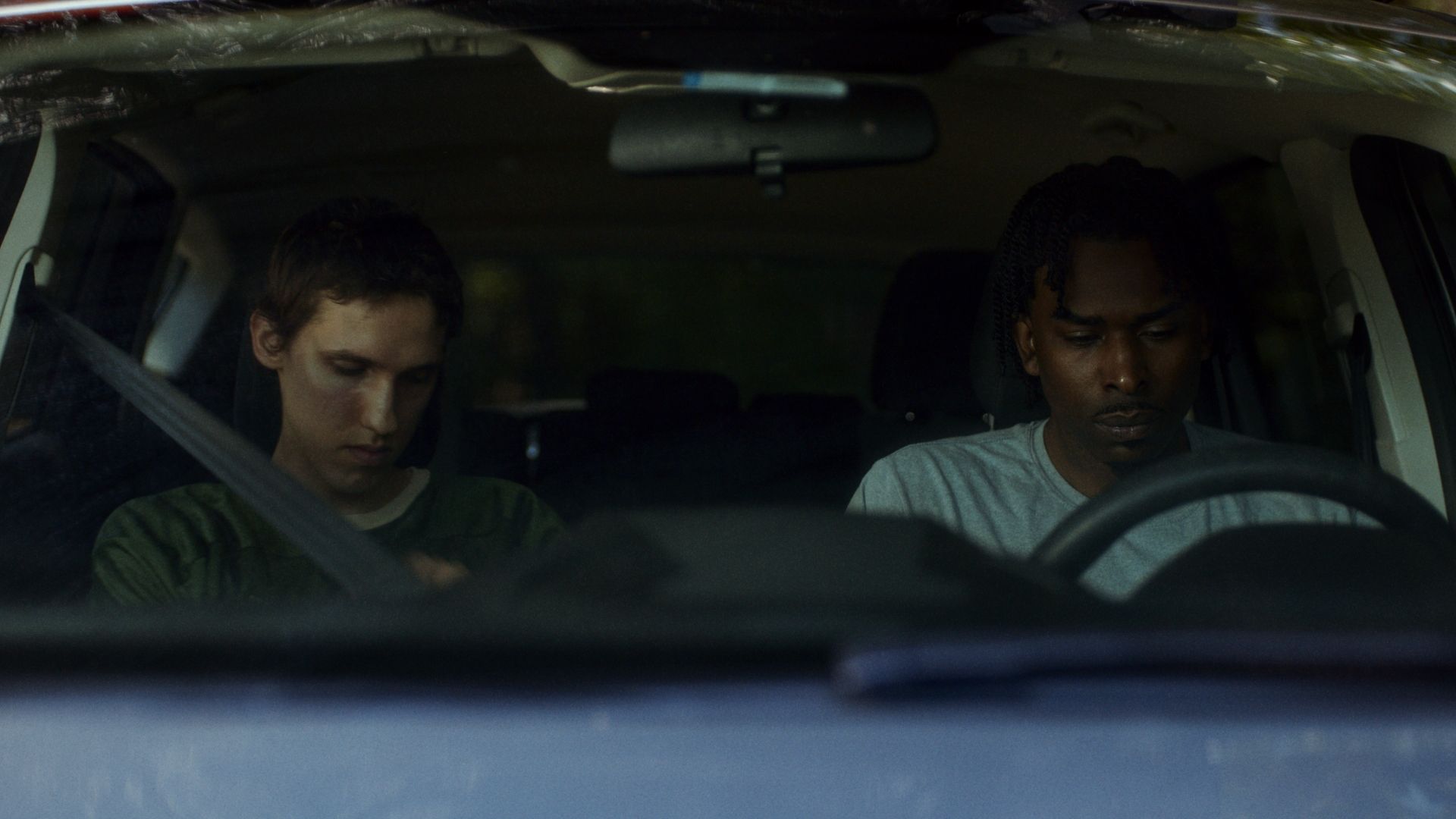 Still from Speak Up: two teammates sit in a parked car after practice